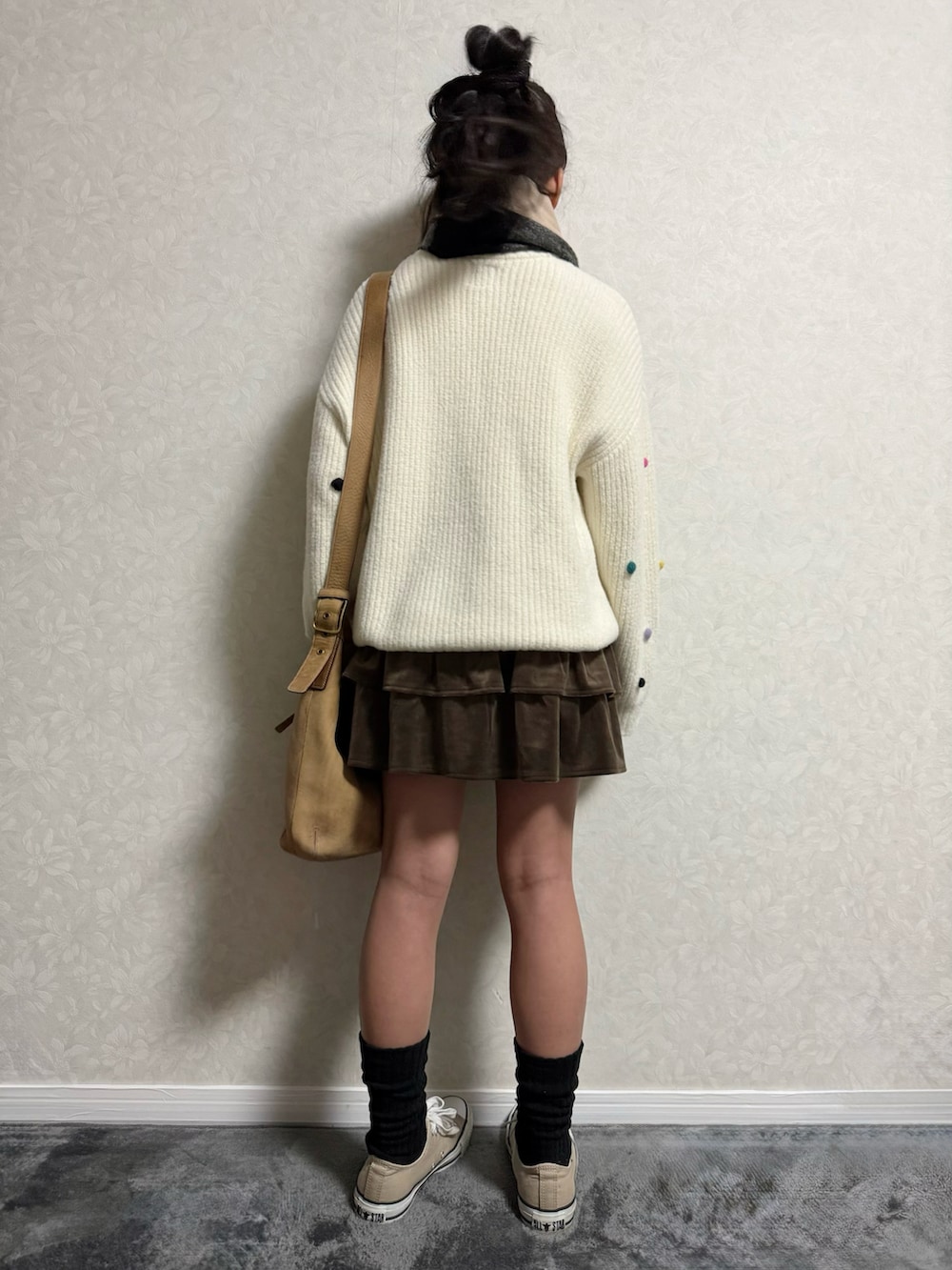 ベージュ系のスニーカー、ホワイト系のニット/セーター、ブラウン系のスカートを着用したキッズの冬コーディネートの2枚目の写真