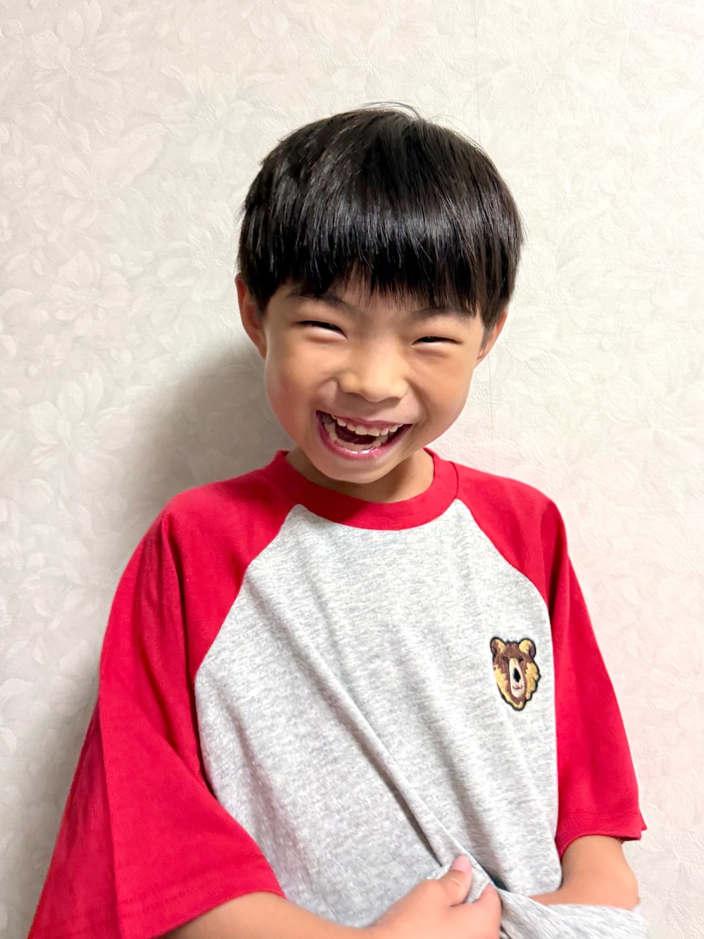 レッド系のTシャツ/カットソー、ブラック系のショルダーバッグ、ブラック系のセットアップを着用したキッズの夏コーディネートの4枚目の写真