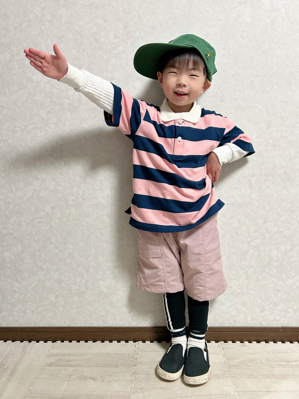 ピンク系のポロシャツ、ピンク系のパンツ、ブラック系のスリッポンを着用したキッズの春コーディネートの3枚目の写真