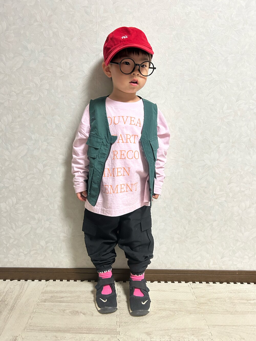 ピンク系のTシャツ/カットソー、グリーン系のベスト、ブラック系のショルダーバッグを着用したキッズの春コーディネートの5枚目の写真