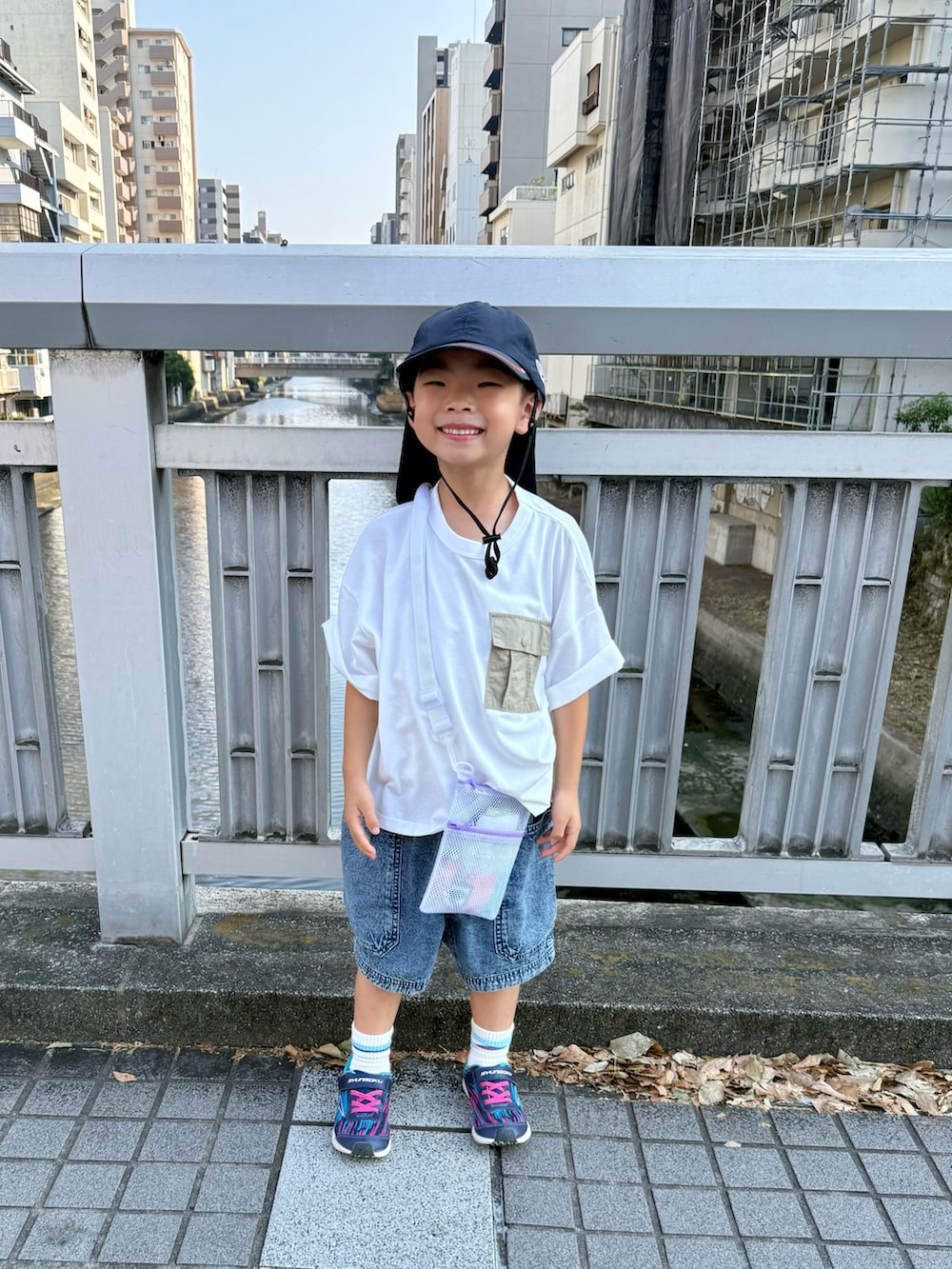 ブルー系のデニムパンツ、ブルー系のスニーカー、ホワイト系のTシャツ/カットソーを着用したキッズの夏コーディネートの3枚目の写真