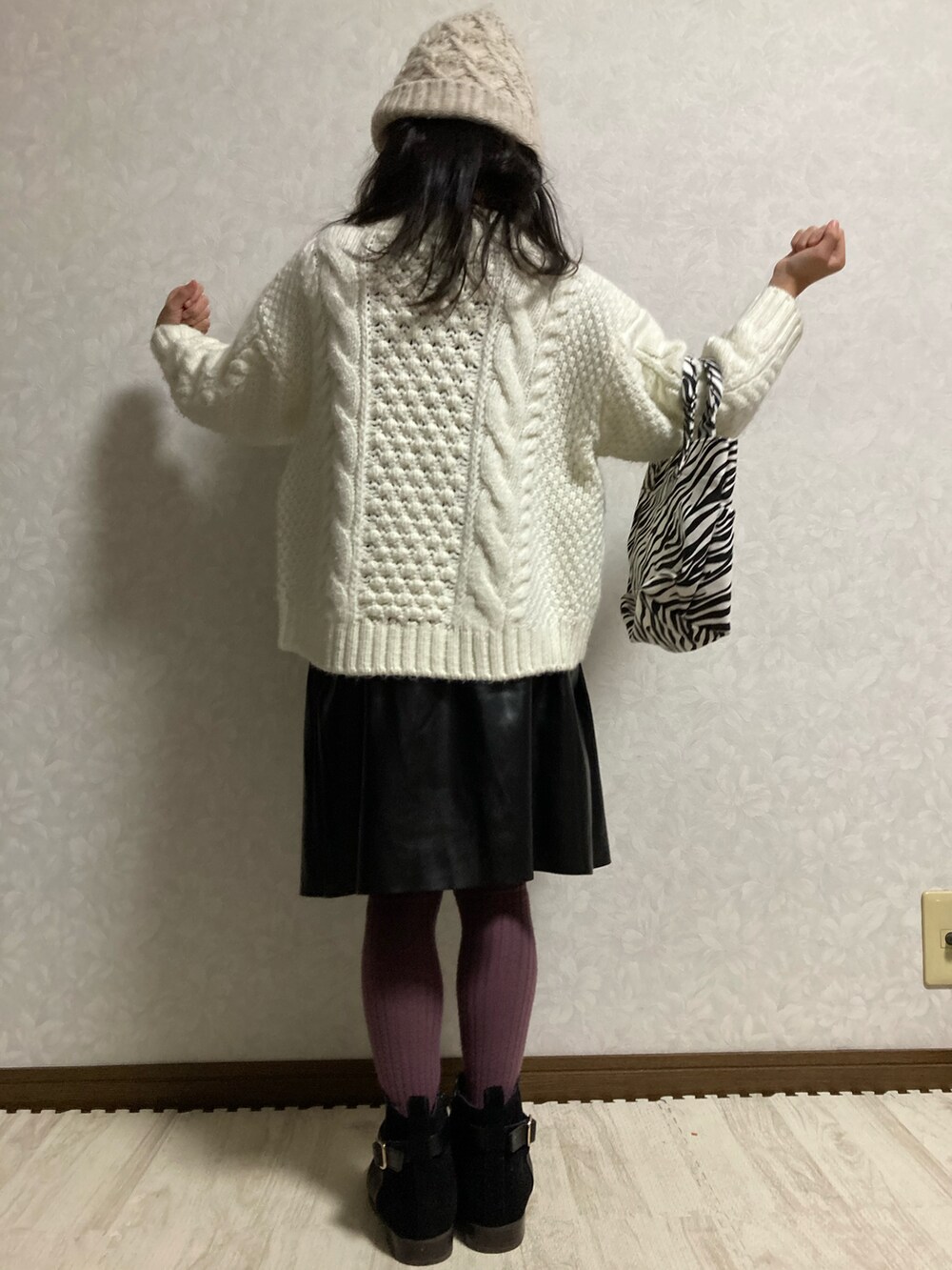 ブラック系のニット/セーター、ホワイト系のカーディガン/ボレロ、ブラック系のスカートを着用したキッズの冬コーディネートの5枚目の写真