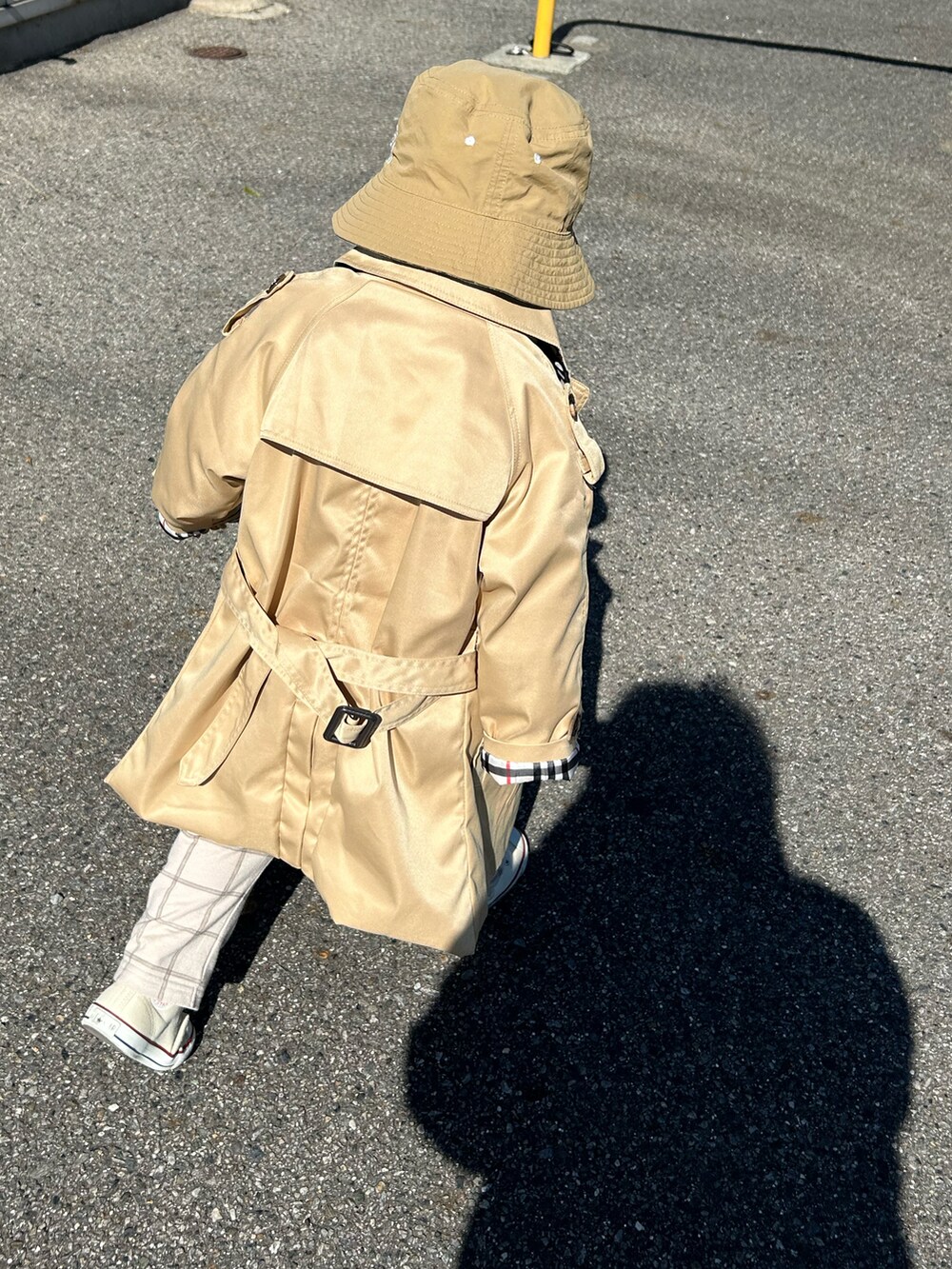 ベージュ系のトレンチコート、ブルー系のニット/セーター、ブルー系のTシャツ/カットソーを着用したキッズの冬コーディネートの5枚目の写真