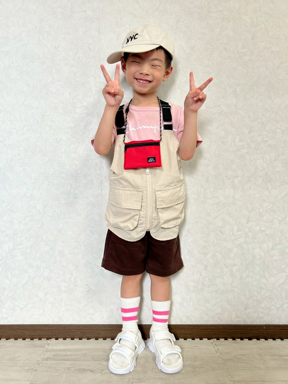 ピンク系のTシャツ/カットソー、ベージュ系のベスト、ブラウン系のパンツを着用したキッズの夏コーディネートの3枚目の写真