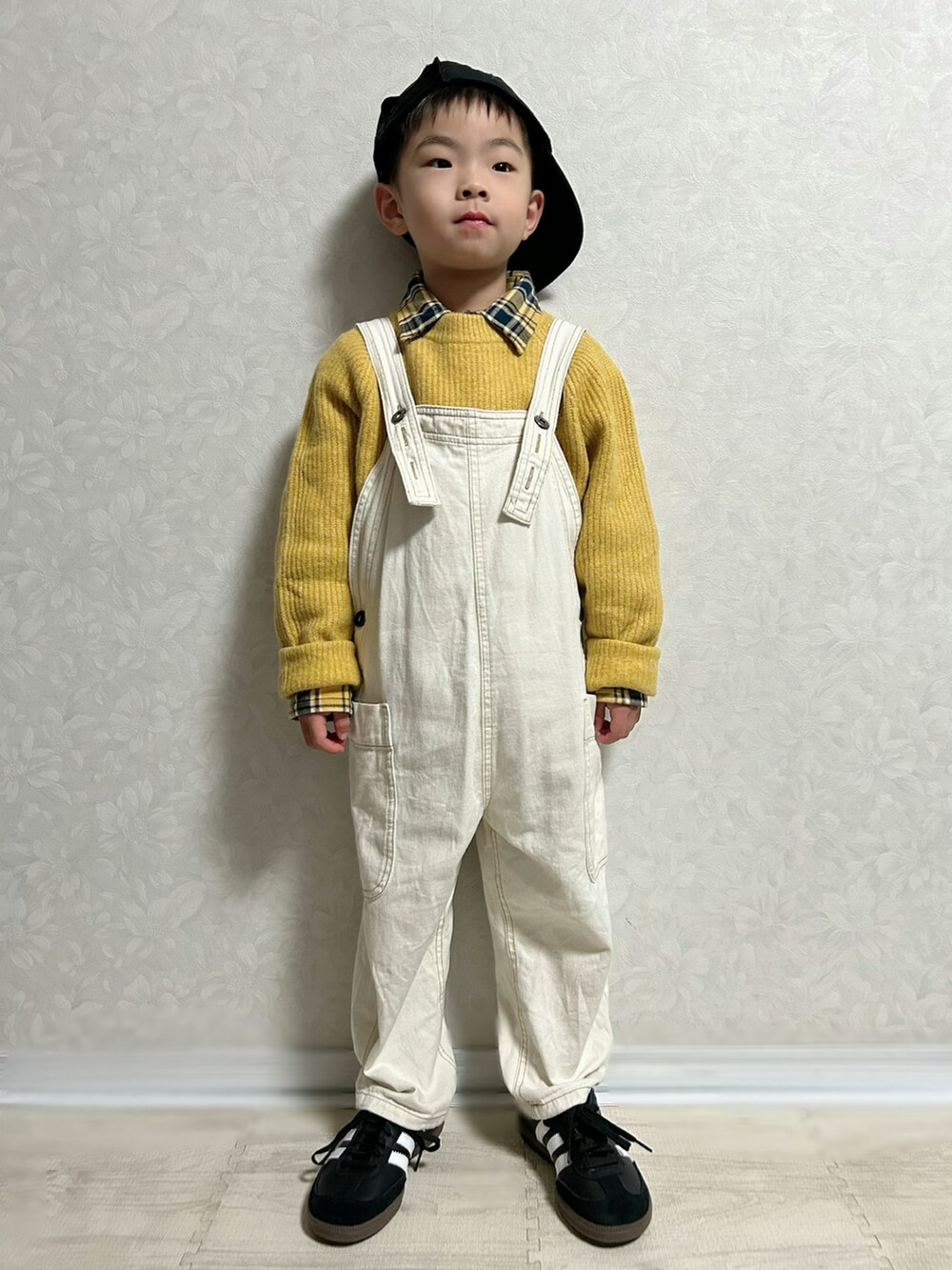 イエロー系のシャツ/ブラウス、イエロー系のニット/セーター、ホワイト系のサロペット/オーバーオールを着用したキッズの冬コーディネートの2枚目の写真