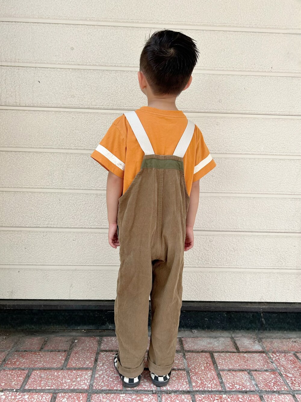 オレンジ系のTシャツ/カットソー、グリーン系のサロペット/オーバーオール、その他のスリッポンを着用したキッズの秋コーディネートの3枚目の写真