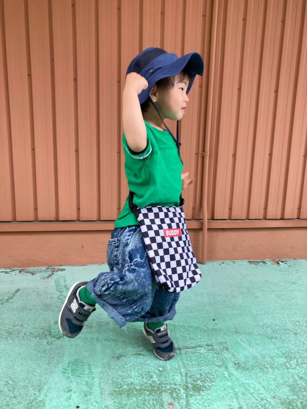 グリーン系のTシャツ/カットソー、ブルー系のデニムパンツ、ブルー系のスニーカーを着用したキッズの夏コーディネートの4枚目の写真