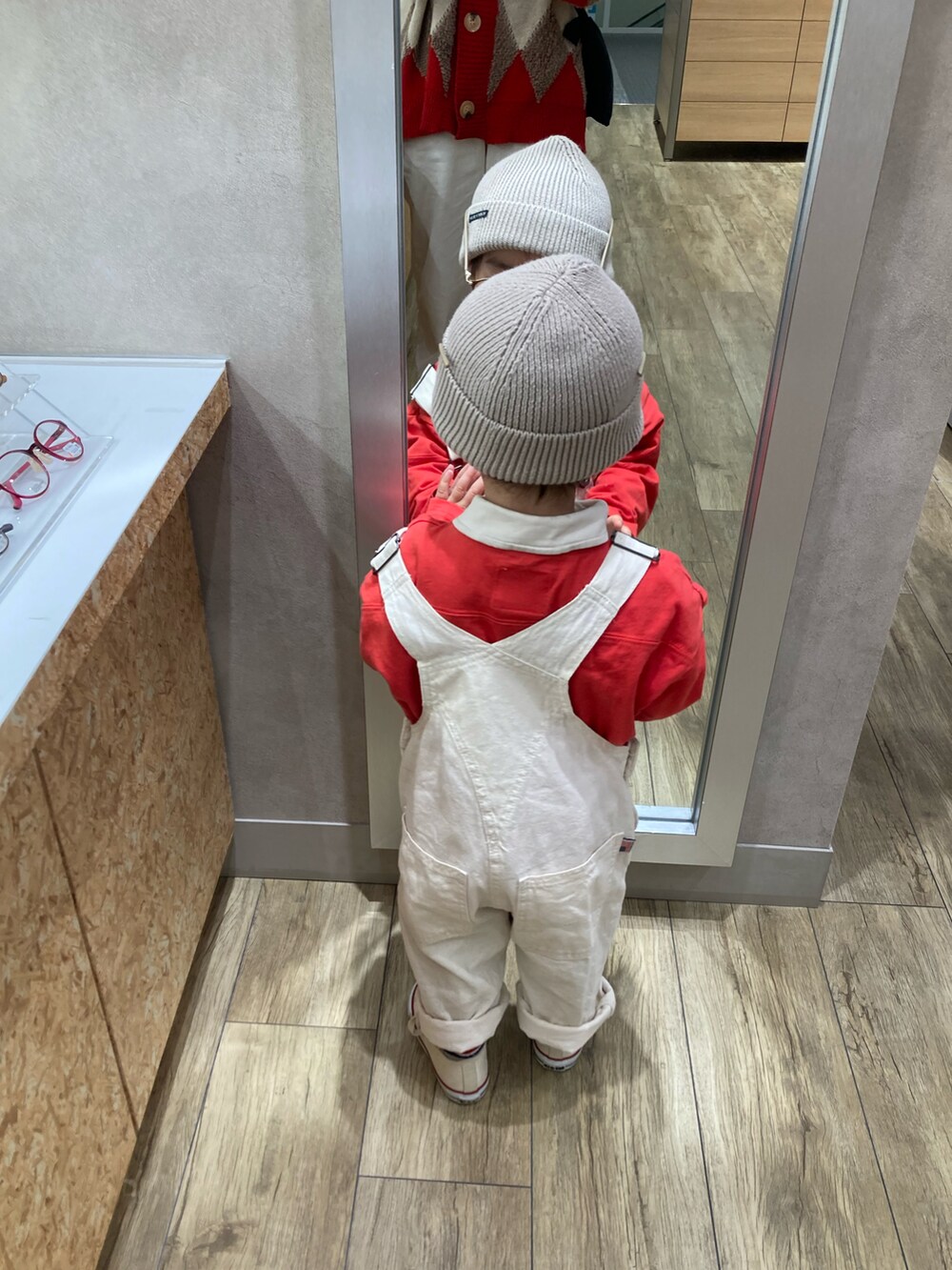 ホワイト系のシャツ/ブラウス、レッド系のTシャツ/カットソー、グリーン系のミリタリージャケットを着用したキッズの冬コーディネートの4枚目の写真