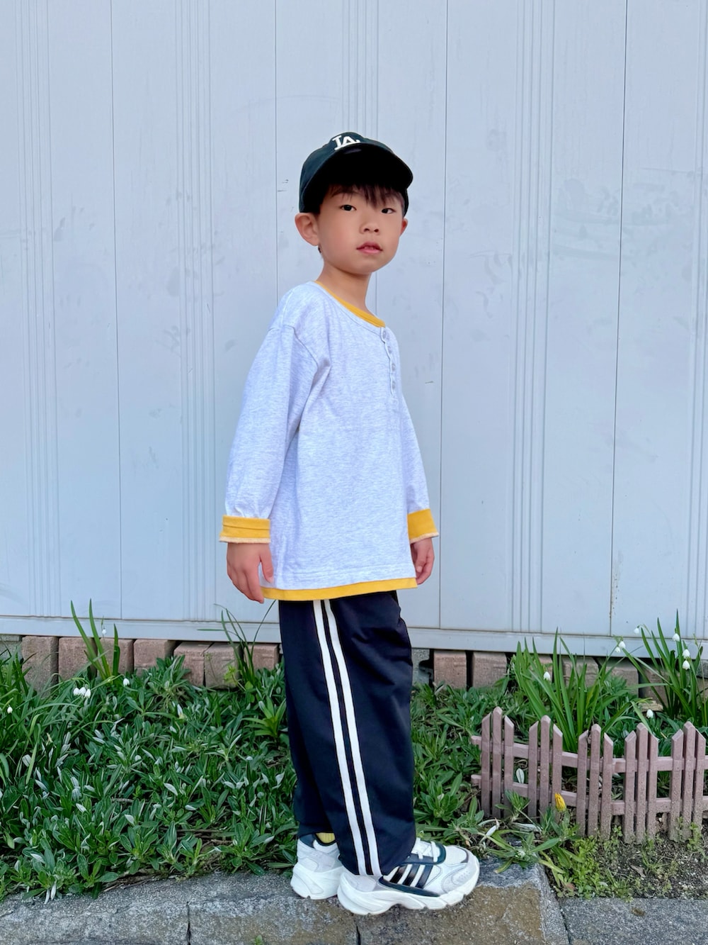 イエロー系のTシャツ/カットソー、ブラック系のその他パンツ、ホワイト系のスニーカーを着用したキッズの春コーディネートの3枚目の写真