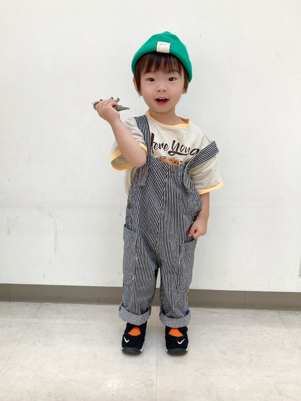 ホワイト系のTシャツ/カットソー、グリーン系のカーディガン/ボレロ、ブラック系のスニーカーを着用したキッズの秋コーディネートの2枚目の写真