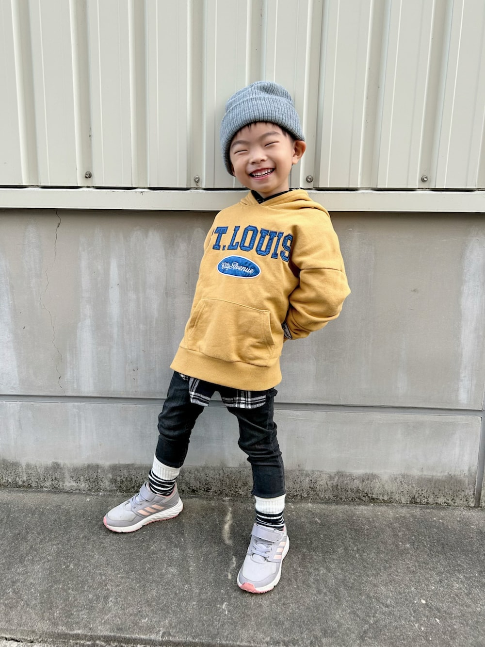 ブラック系のシャツ/ブラウス、イエロー系のパーカー、ブラック系のデニムパンツを着用したキッズの冬コーディネートの2枚目の写真