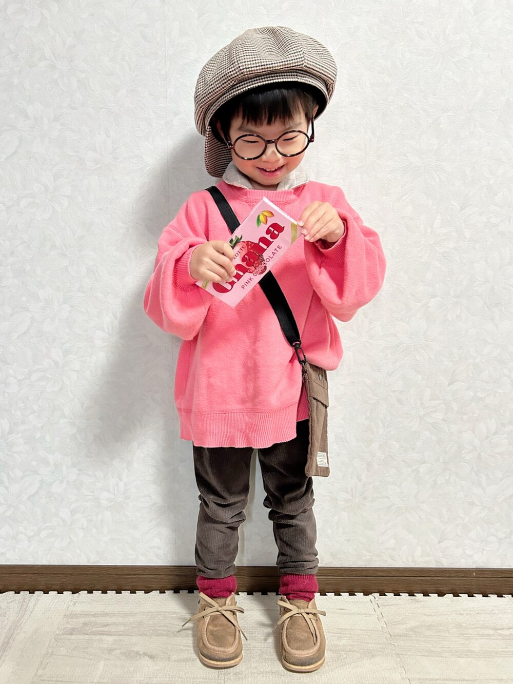 ピンク系のニット/セーター、ベージュ系のセットアップ、ブラウン系のショルダーバッグを着用したキッズの冬コーディネートの5枚目の写真