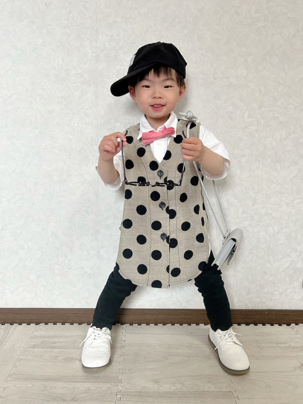 ホワイト系のシャツ/ブラウス、ベージュ系のベスト、レッド系の蝶ネクタイを着用したキッズの春コーディネートの3枚目の写真