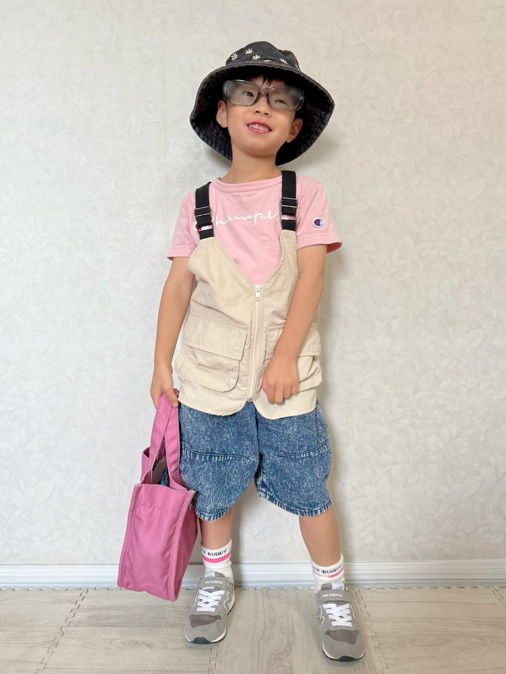 ベージュ系のベスト、ピンク系のTシャツ/カットソー、グレー系のスニーカーを着用したキッズの夏コーディネートの2枚目の写真