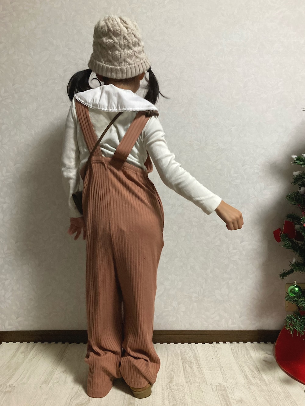 ホワイト系のTシャツ/カットソー、オレンジ系のサロペット/オーバーオール、ベージュ系のブーツを着用したキッズの冬コーディネートの4枚目の写真