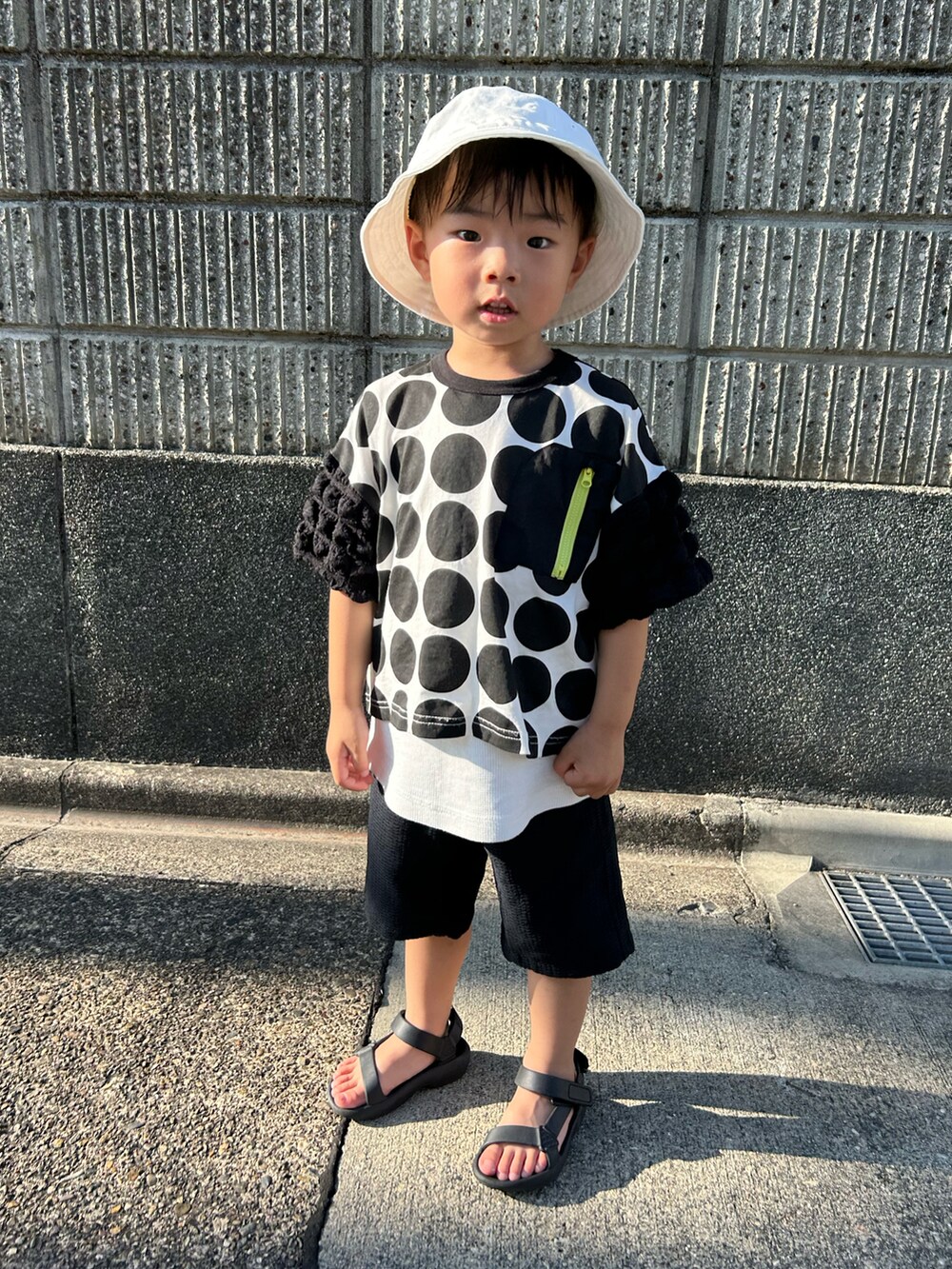 ブラック系のベスト、ブラック系のシャツ/ブラウス、ホワイト系のサンダルを着用したキッズの夏コーディネートの4枚目の写真