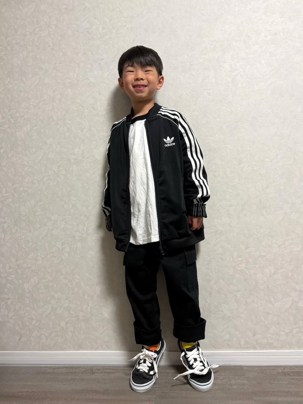 ホワイト系のTシャツ/カットソー、ブラック系のジャージ、ブラック系のスニーカーを着用したキッズの春コーディネートの2枚目の写真