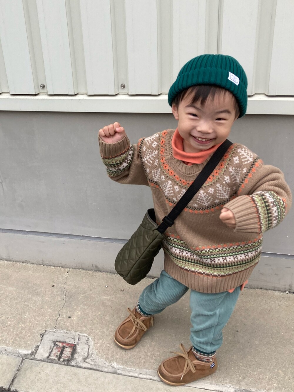 ベージュ系のニット/セーター、オレンジ系のスウェット、グリーン系のその他パンツを着用したキッズの秋コーディネートの3枚目の写真