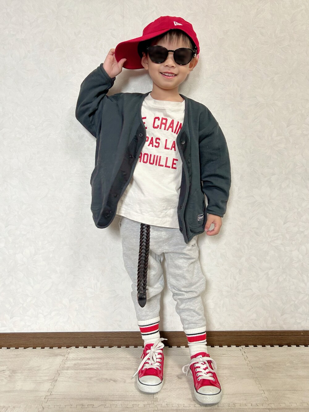 ブラック系のカーディガン/ボレロ、ホワイト系のTシャツ/カットソー、グレー系のスウェットパンツを着用したキッズの秋コーディネートの2枚目の写真