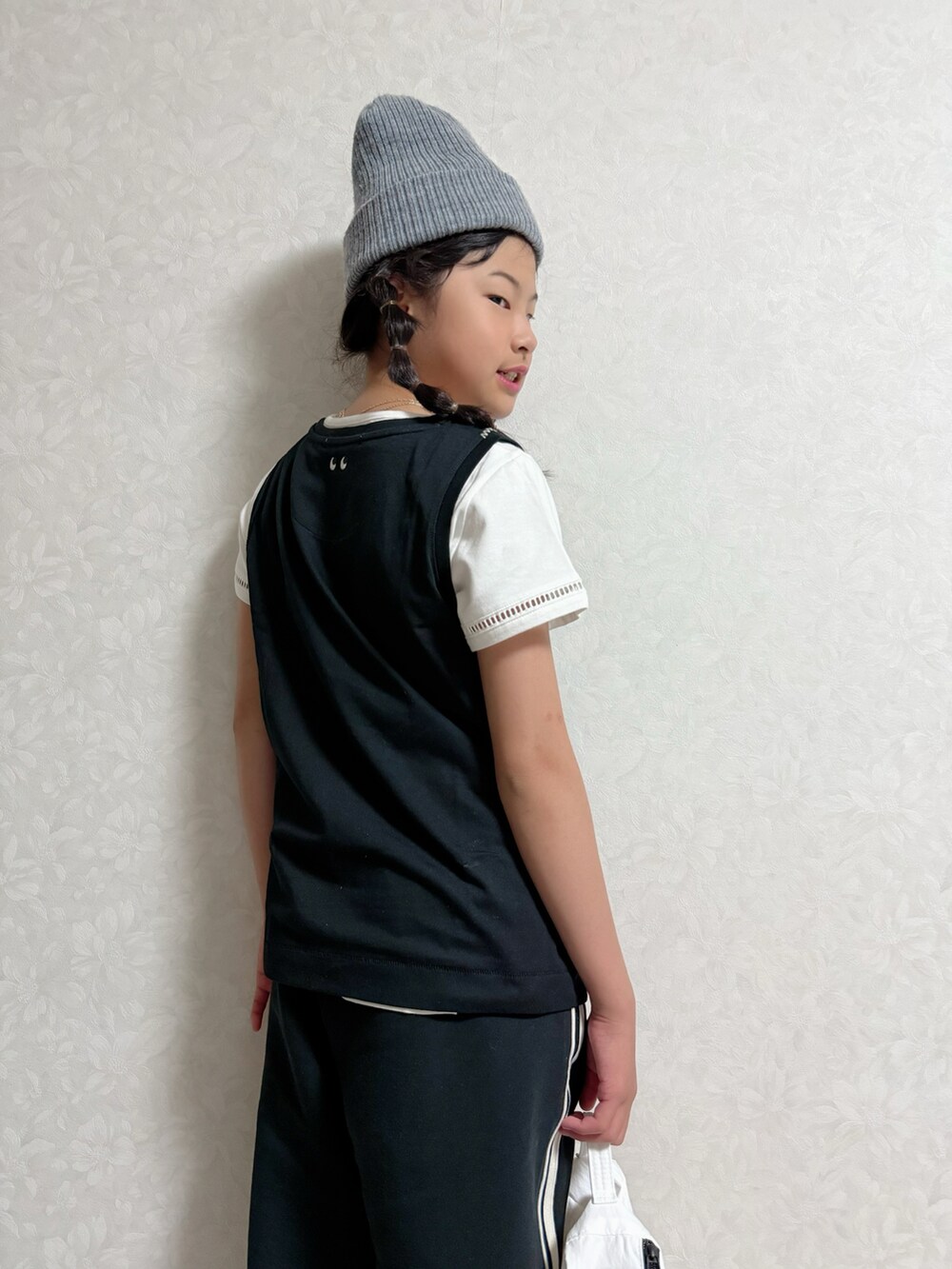 ブラック系のタンクトップ、ホワイト系のセットアップ、ブラック系のスウェットパンツを着用したキッズの春コーディネートの3枚目の写真