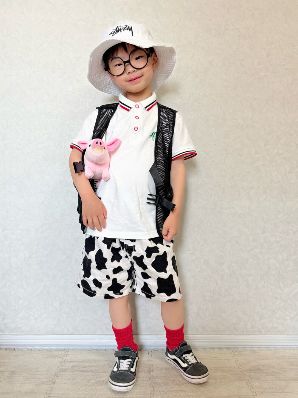 ホワイト系のポロシャツ、ホワイト系のパンツ、ブラック系のベストを着用したキッズの春コーディネートの4枚目の写真
