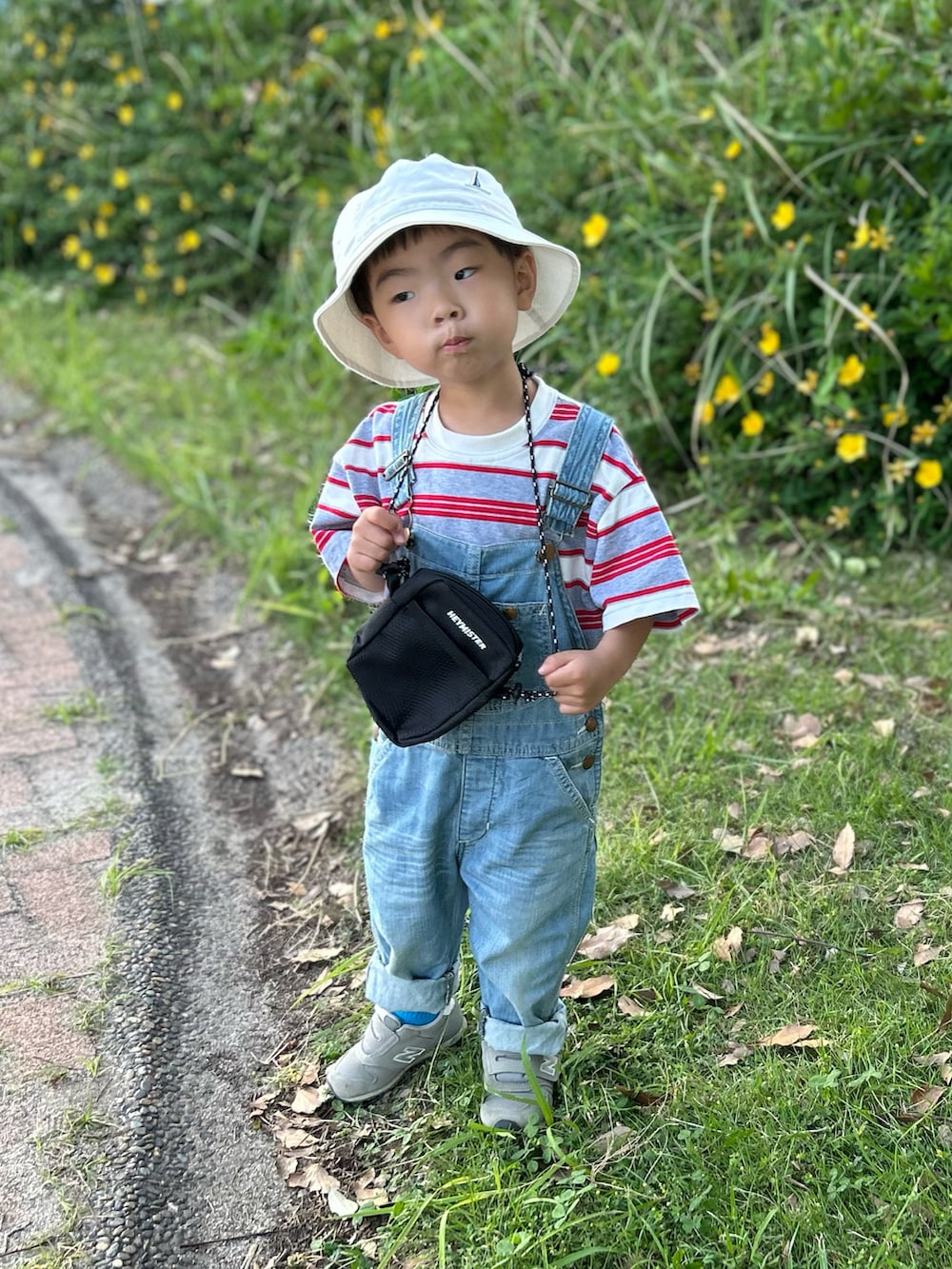 グレー系のTシャツ/カットソー、ブルー系のサロペット/オーバーオール、ブラック系のショルダーバッグを着用したキッズの夏コーディネートの2枚目の写真