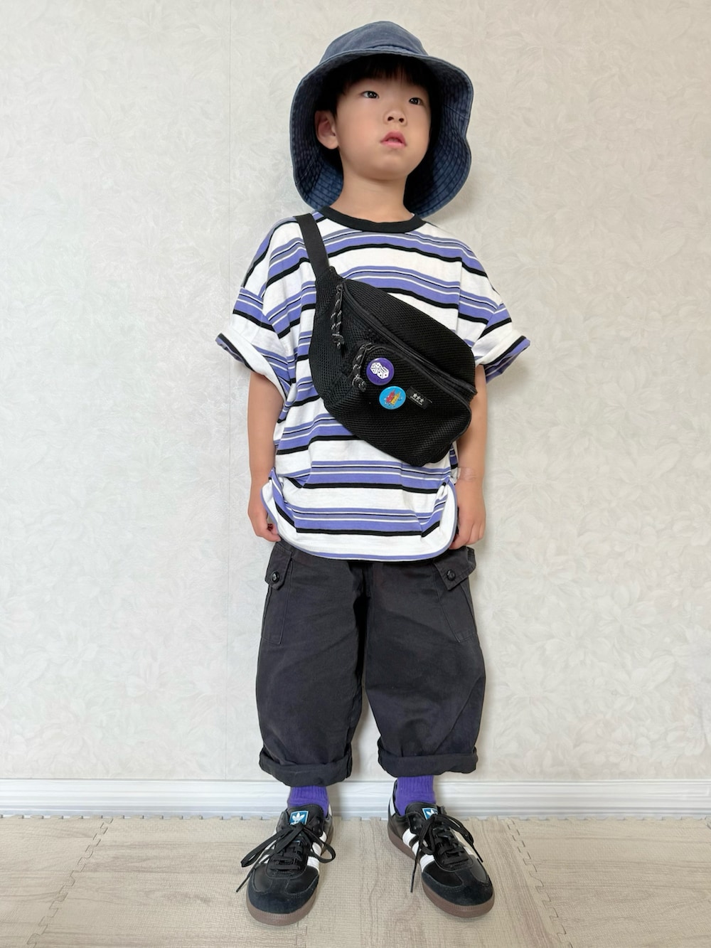 パープル系のTシャツ/カットソー、ブラック系のスニーカー、ブラック系のカーゴパンツを着用したキッズの夏コーディネートの2枚目の写真