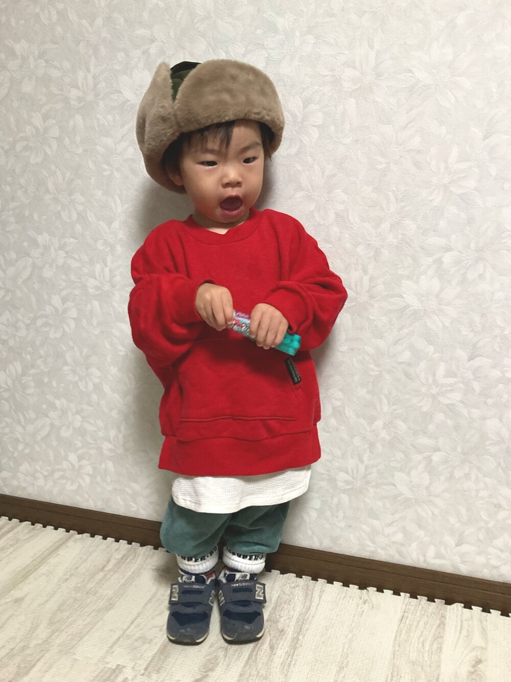 レッド系のスウェット、グリーン系のミリタリージャケット、グリーン系のその他パンツを着用したキッズの秋コーディネートの3枚目の写真