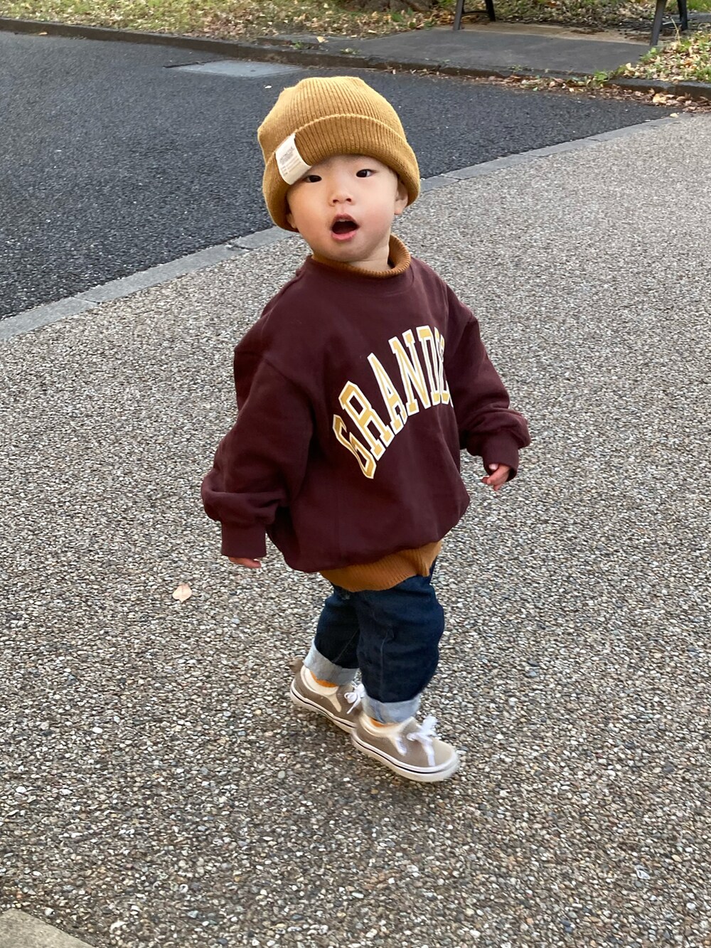 イエロー系のニット/セーター、ブラウン系のスウェット、ブルー系のデニムパンツを着用したキッズの冬コーディネートの2枚目の写真