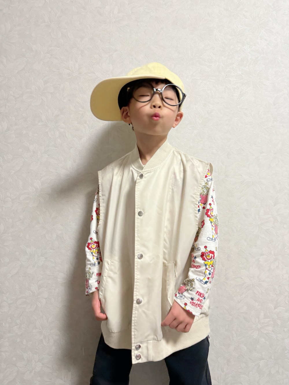 ベージュ系のベスト、ベージュ系のTシャツ/カットソー、ホワイト系のスニーカーを着用したキッズの冬コーディネートの2枚目の写真