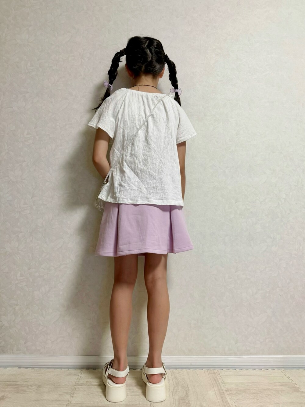 ホワイト系のサンダル、ホワイト系のTシャツ/カットソー、パープル系のスカートを着用したキッズの夏コーディネートの3枚目の写真