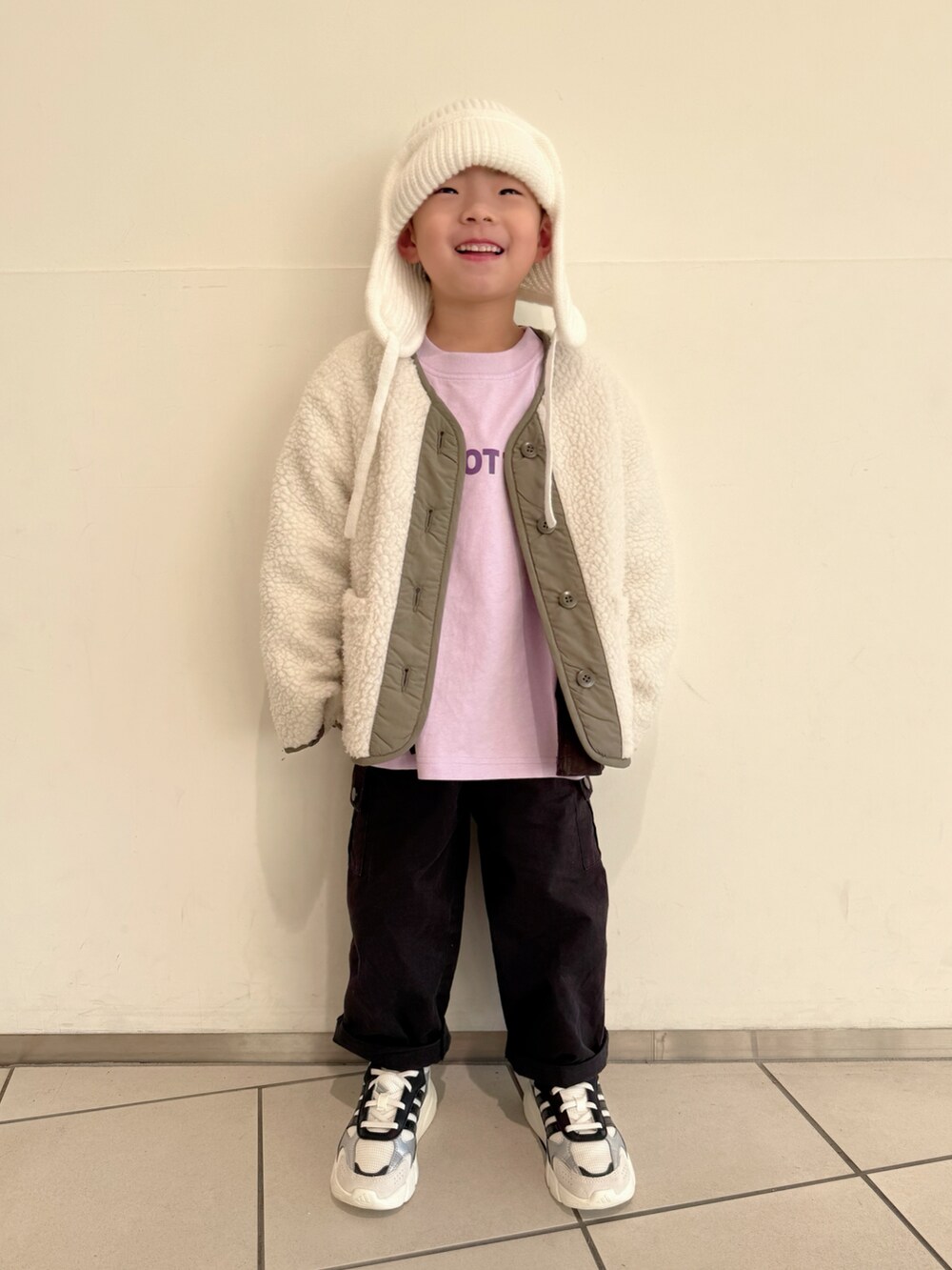 パープル系のTシャツ/カットソー、グリーン系のノーカラージャケット、ブラック系のボディバッグ/ウエストポーチを着用したキッズの冬コーディネートの5枚目の写真