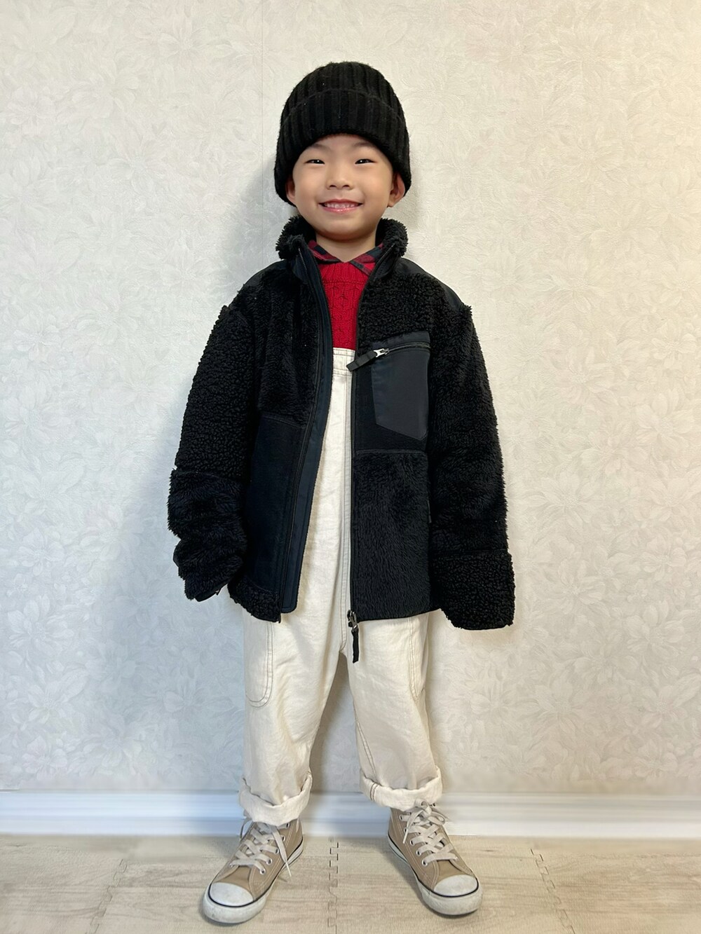 レッド系のシャツ/ブラウス、レッド系のニット/セーター、ホワイト系のサロペット/オーバーオールを着用したキッズの冬コーディネートの2枚目の写真