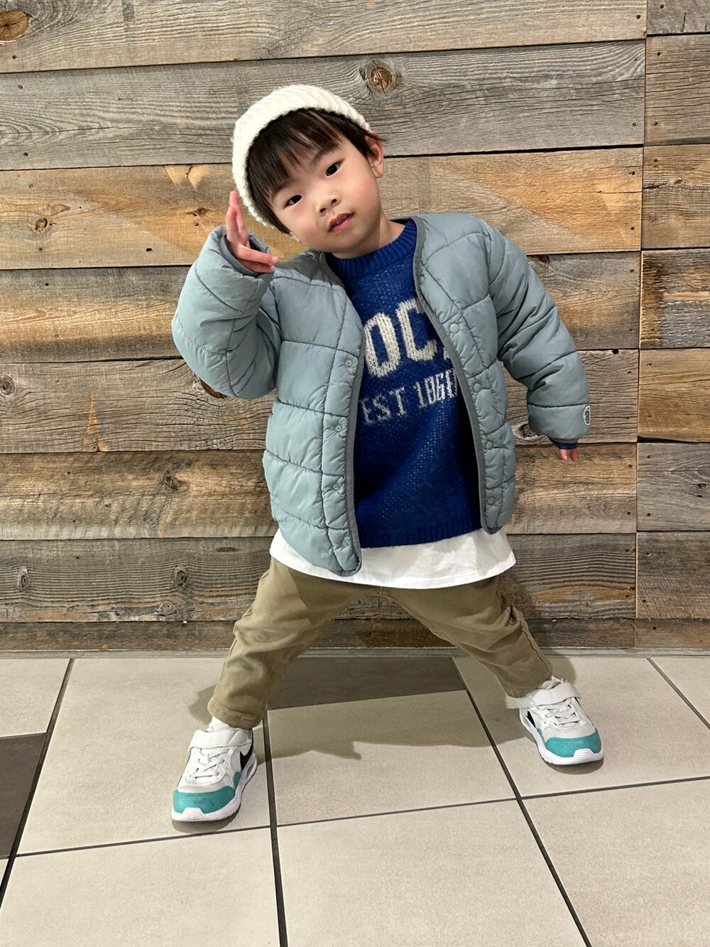 ブルー系のニット/セーター、ベージュ系のその他パンツ、ホワイト系のスニーカーを着用したキッズの冬コーディネートの3枚目の写真