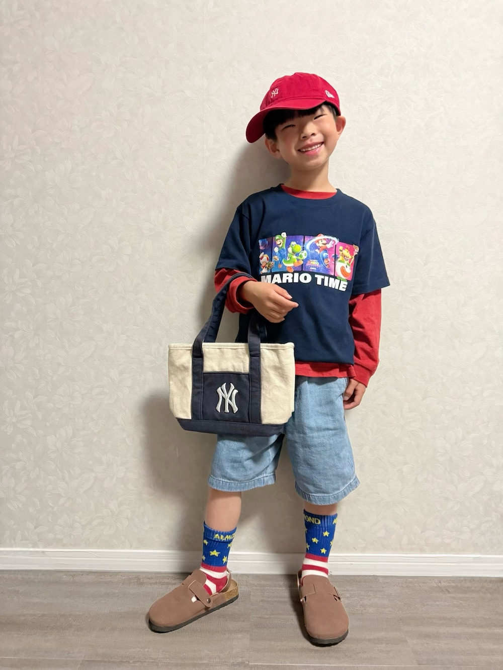 レッド系のTシャツ/カットソー、ホワイト系のショルダーバッグ、ブルー系のTシャツ/カットソーを着用したキッズの春コーディネートの2枚目の写真