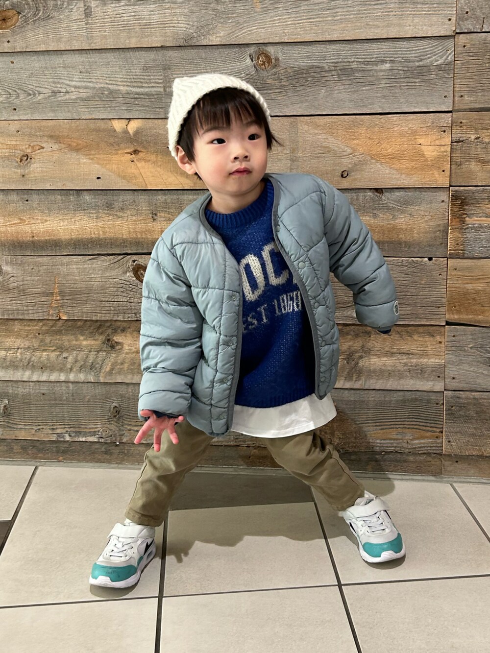 ブルー系のニット/セーター、ベージュ系のその他パンツ、ホワイト系のスニーカーを着用したキッズの冬コーディネートの5枚目の写真