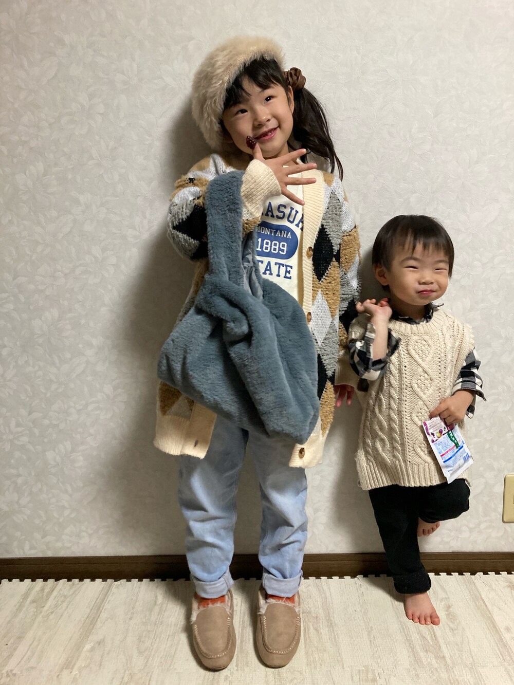 ベージュ系のカーディガン/ボレロ、ホワイト系のTシャツ/カットソー、ブルー系のデニムパンツを着用したキッズの冬コーディネートの3枚目の写真