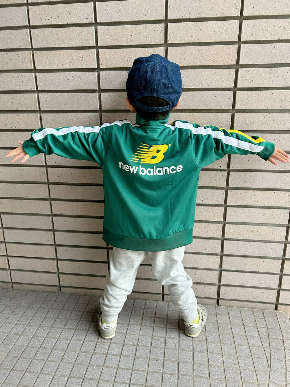 ホワイト系のスウェット、グリーン系のジャージ、グレー系のスウェットパンツを着用したキッズの秋コーディネートの2枚目の写真