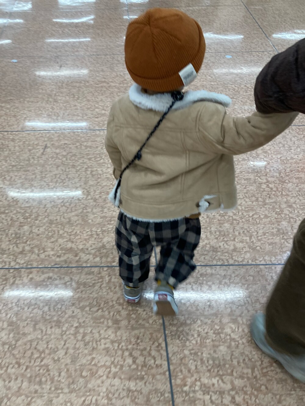 イエロー系のニット/セーター、ホワイト系のニット/セーター、ベージュ系のジャケット/アウターを着用したキッズの冬コーディネートの3枚目の写真