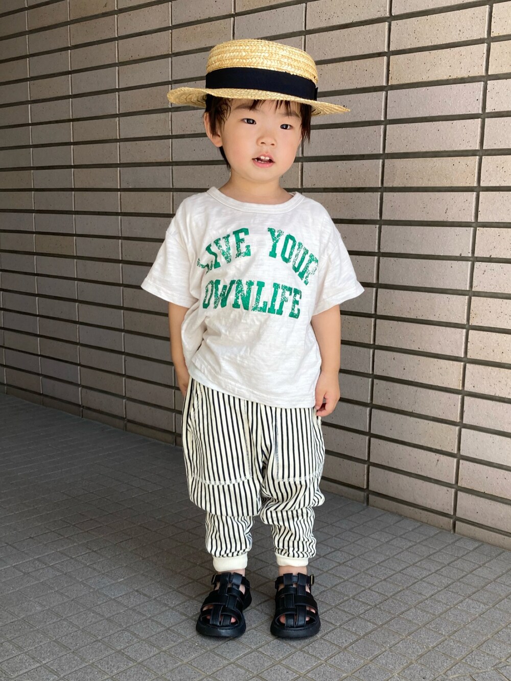 ベージュ系のTシャツ/カットソー、ブルー系のその他パンツ、ブラック系のサンダルを着用したキッズの夏コーディネートの2枚目の写真