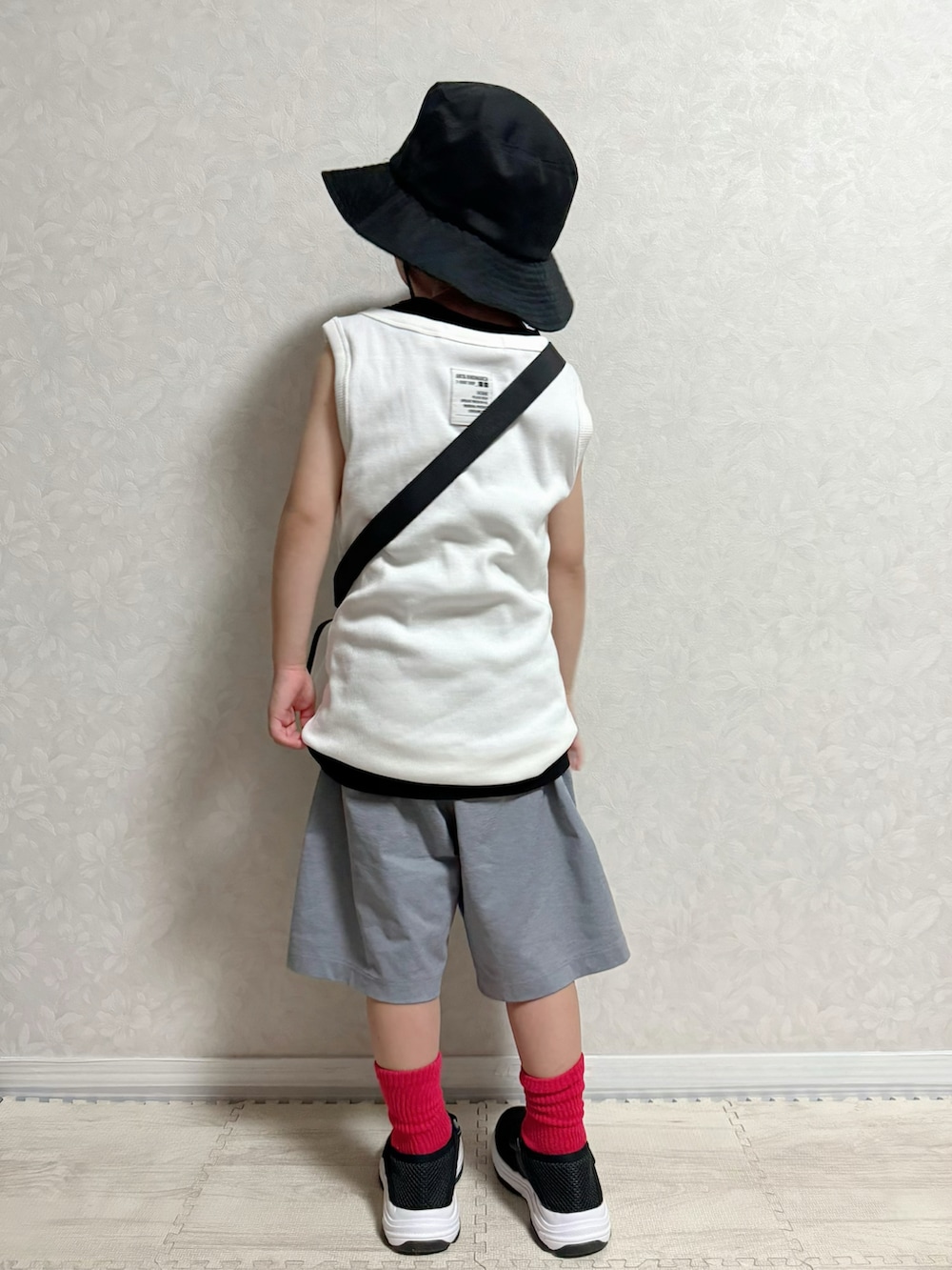 グレー系のパンツ、ブラック系のサンダル、ホワイト系のタンクトップを着用したキッズの夏コーディネートの3枚目の写真