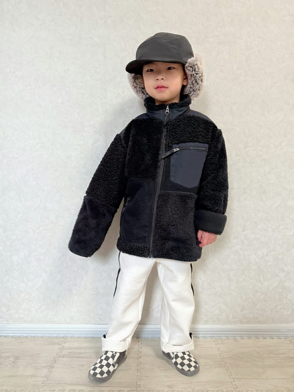 ブラック系のジャケット/アウター、グリーン系のTシャツ/カットソー、ホワイト系のスウェットパンツを着用したキッズの冬コーディネートの4枚目の写真