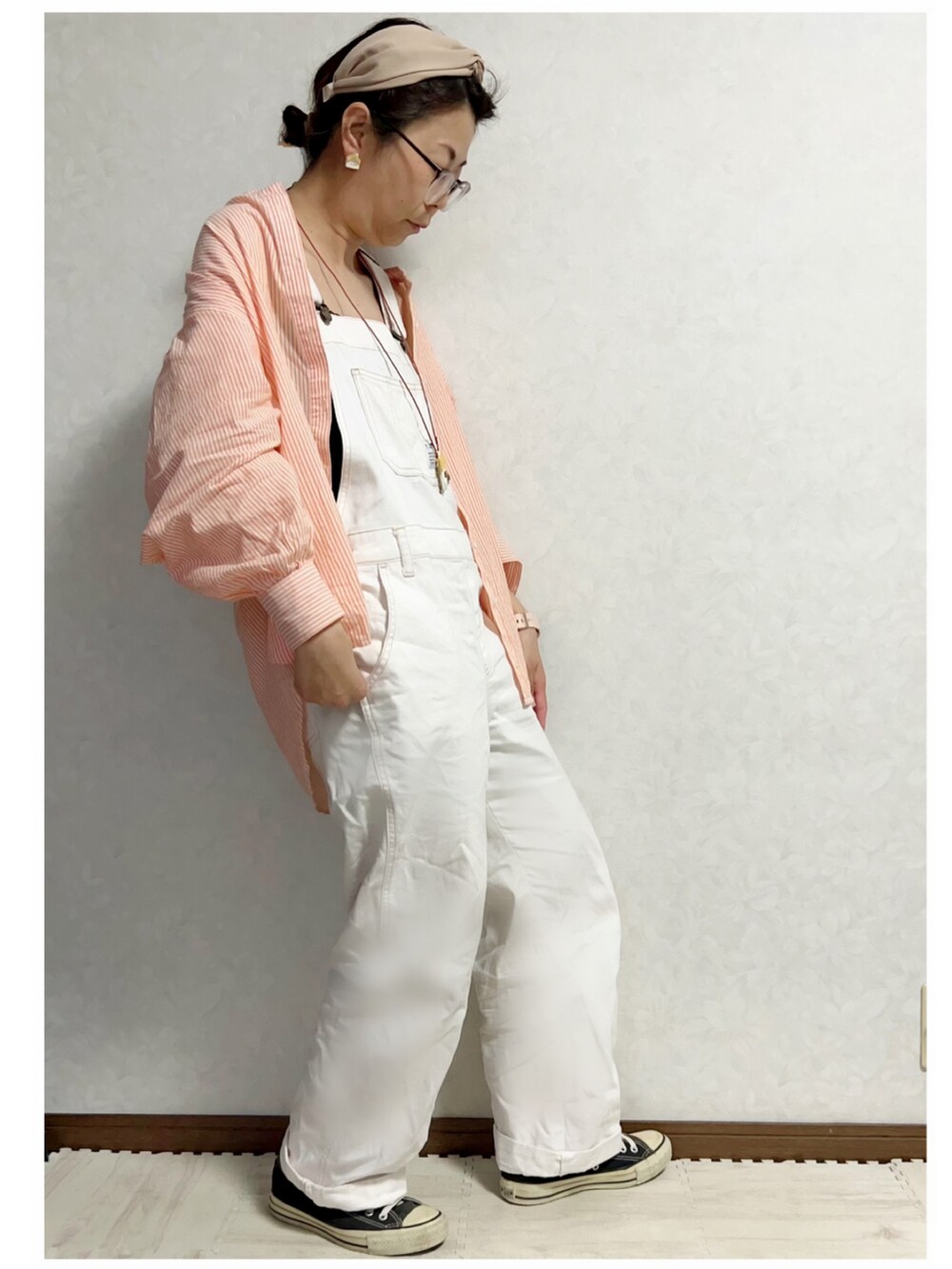 オレンジ系のシャツ/ブラウス、グリーン系のポンチョ、ホワイト系のジャンパースカートを着用したキッズの春コーディネートの5枚目の写真