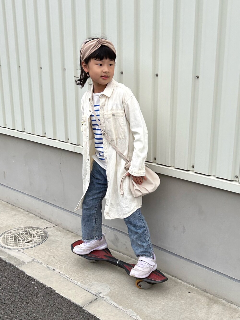 ブルー系のTシャツ/カットソー、ホワイト系のワンピース、ブルー系のデニムパンツを着用したキッズの春コーディネートの2枚目の写真