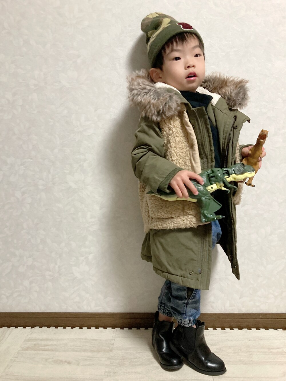 ブラック系のTシャツ/カットソー、グリーン系のモッズコート、ベージュ系のベストを着用したキッズの冬コーディネートの5枚目の写真