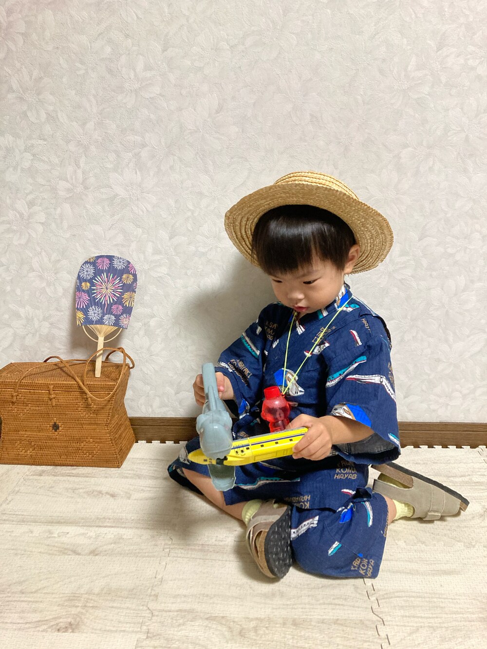 ベージュ系のサンダル、ブラウン系のかごバッグ、ベージュ系のハットを着用したキッズの夏コーディネートの4枚目の写真