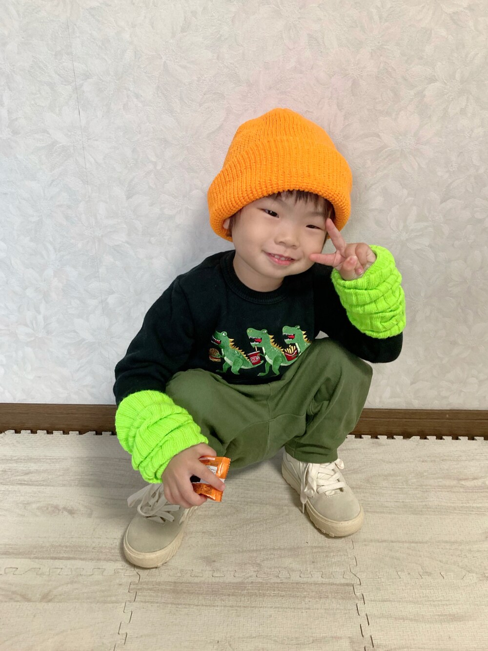 ブラック系のスウェット、オレンジ系のタンクトップ、グリーン系のパンツを着用したキッズの秋コーディネートの5枚目の写真