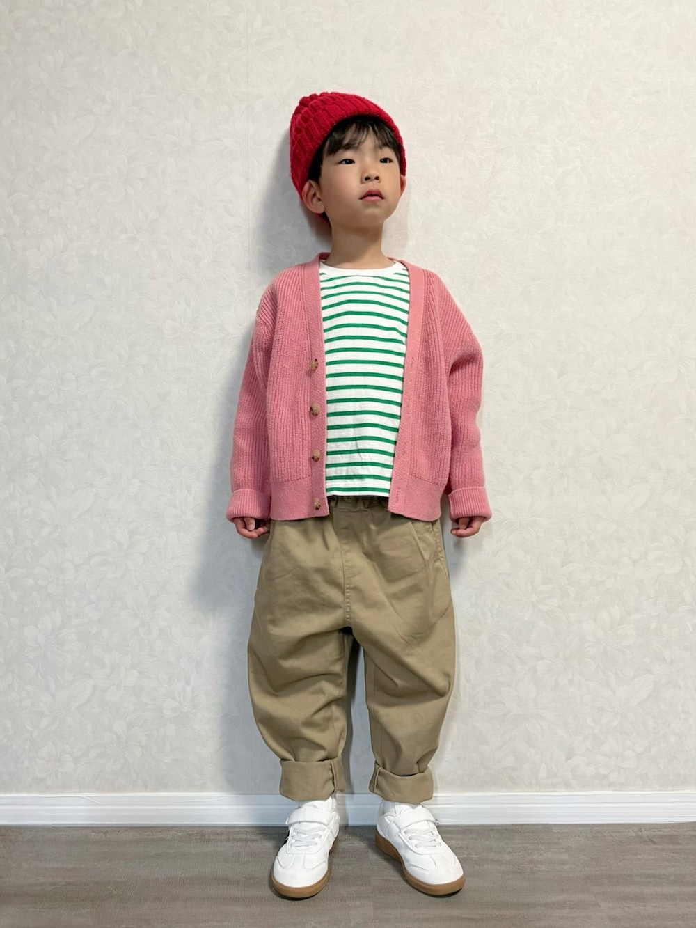グリーン系のTシャツ/カットソー、ピンク系のカーディガン/ボレロ、ベージュ系のチノパンツを着用したキッズの春コーディネートの3枚目の写真