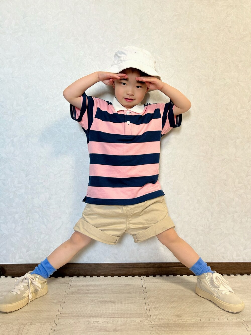 ピンク系のポロシャツ、ベージュ系のチノパンツ、ホワイト系のスニーカーを着用したキッズの春コーディネートの3枚目の写真