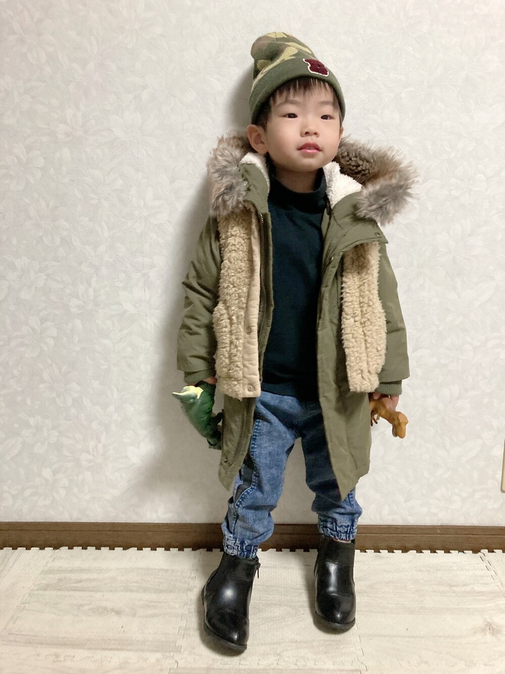 ブラック系のTシャツ/カットソー、グリーン系のモッズコート、ベージュ系のベストを着用したキッズの冬コーディネートの3枚目の写真